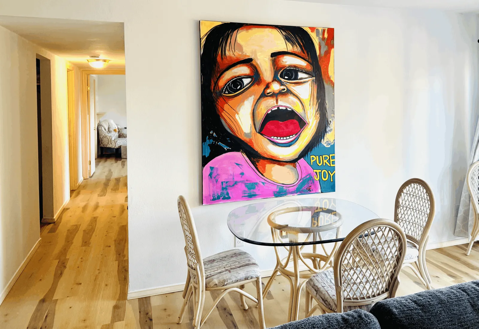 Dining table at the Lakeside Retreat beneath a large 'Pure Joy' portrait painting