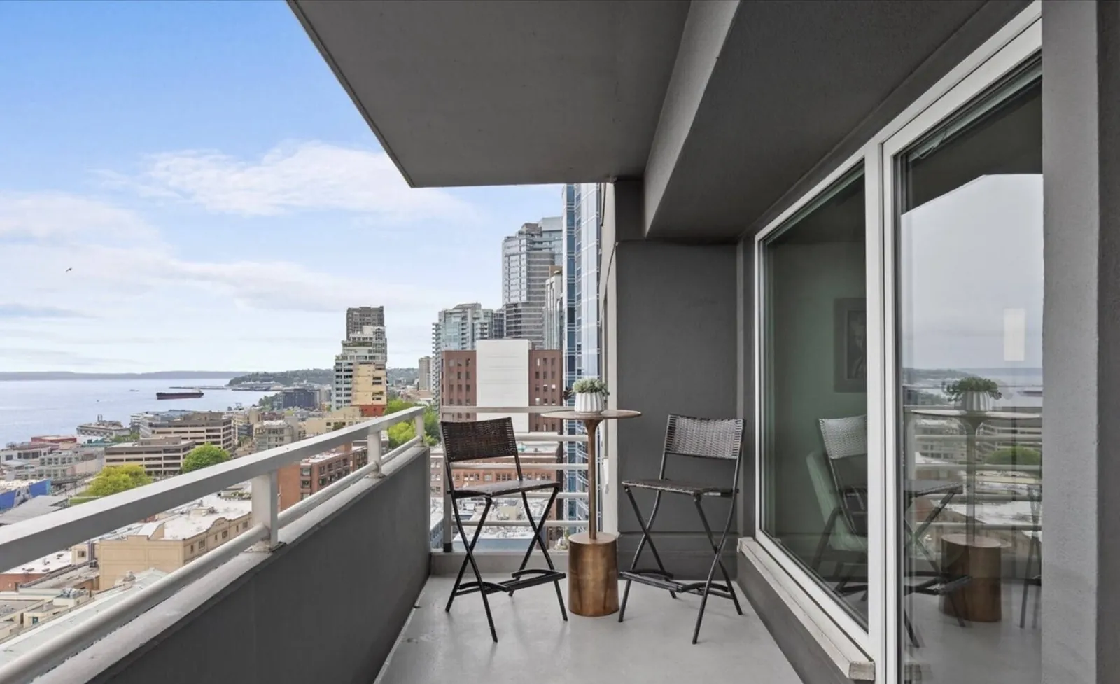 Bistro table and chairs on the OceanView condo balcony, above downtown Seattle and Elliott Bay