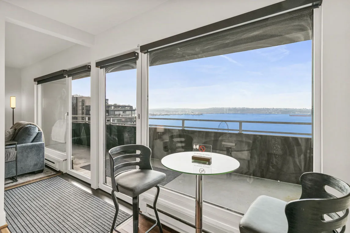 Balcony table and chairs at a downtown Seattle waterfront rental, looking out over Puget Sound