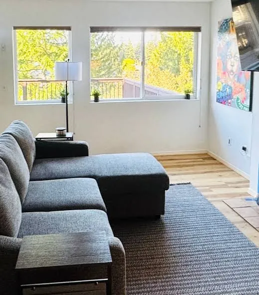 Lakeside Retreat living room with sectional sofa and deck-view windows