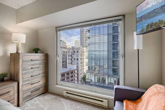Pike Place Condo master bedroom with floor-to-ceiling downtown Seattle window